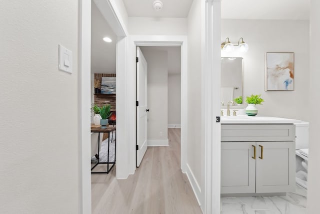 13322 Villa Park Dr, Austin, TX 78729 - corridor featuring light wood-style floors, a sink, and baseboards