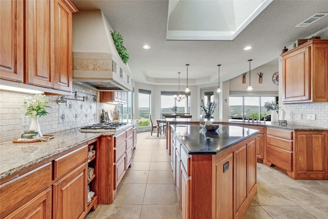 17400 Northlake Hills Dr, Jonestown, TX 78645 - kitchen with a raised ceiling, backsplash, healthy amount of natural light, dark stone countertops, and recessed lighting