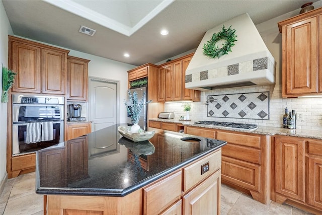 17400 Northlake Hills Dr, Jonestown, TX 78645 - kitchen featuring custom range hood, appliances with stainless steel finishes, recessed lighting, dark stone countertops, and decorative backsplash