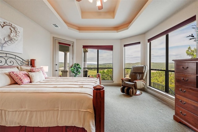 17400 Northlake Hills Dr, Jonestown, TX 78645 - carpeted bedroom with access to outside, multiple windows, a tray ceiling, and a ceiling fan