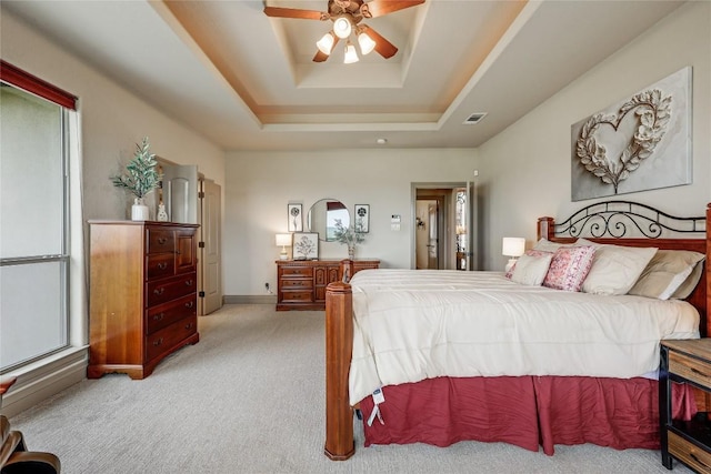 17400 Northlake Hills Dr, Jonestown, TX 78645 - carpeted bedroom with a tray ceiling, multiple windows, and a ceiling fan