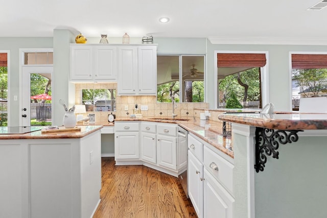 3808 Royal Troon Dr, Round Rock, TX 78664 - kitchen with healthy amount of natural light, light wood-style flooring, white cabinetry, recessed lighting, and crown molding
