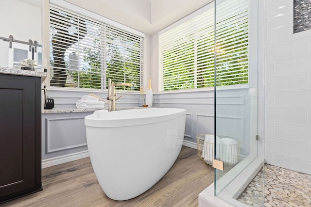3808 Royal Troon Dr, Round Rock, TX 78664 - bathroom featuring wood finished floors, a freestanding tub, vanity, and a stall shower