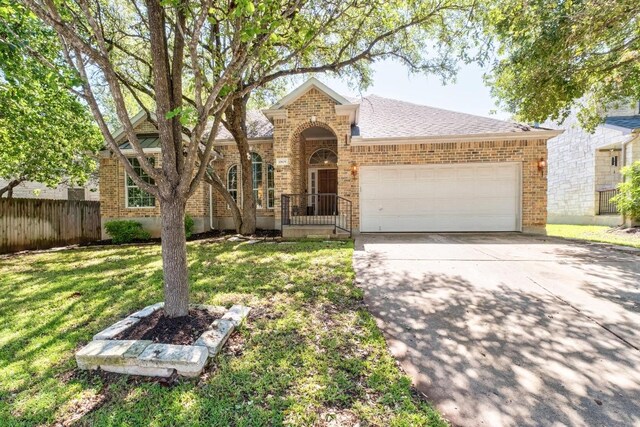 10609 Thoroughbred Dr, Austin, TX 78748 - traditional-style house featuring brick siding, an attached garage, concrete driveway, and roof with shingles