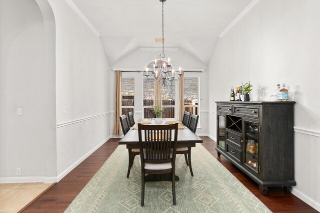 10609 Thoroughbred Dr, Austin, TX 78748 - dining room featuring arched walkways, a chandelier, baseboards, vaulted ceiling, and dark wood-type flooring