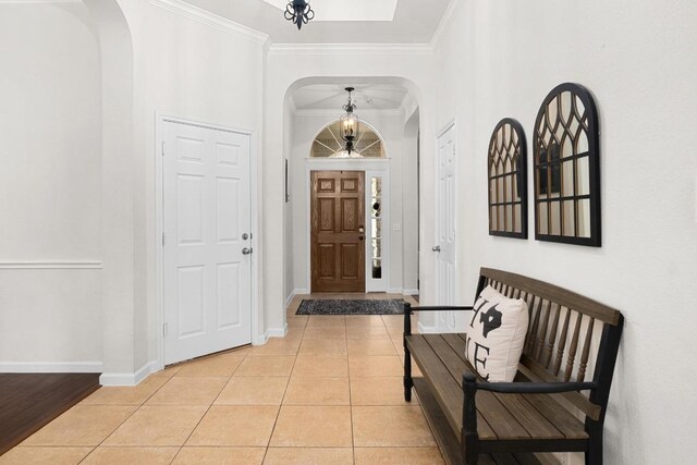 10609 Thoroughbred Dr, Austin, TX 78748 - entrance foyer with arched walkways, light tile patterned floors, baseboards, and crown molding