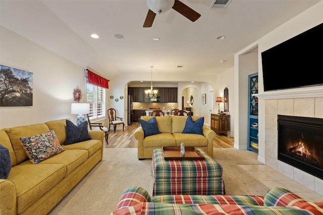 1049 Naranjo Dr, Georgetown, TX 78628 - living area featuring arched walkways, ceiling fan, a tiled fireplace, a chandelier, and recessed lighting