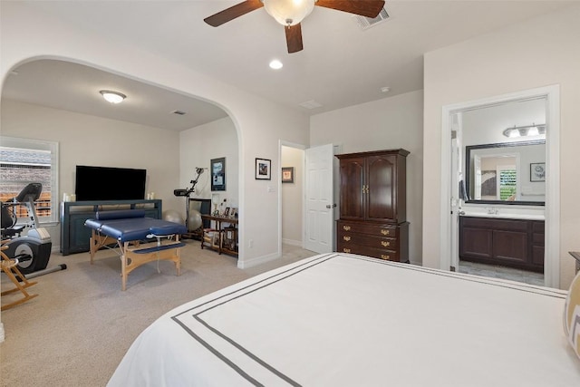 1049 Naranjo Dr, Georgetown, TX 78628 - bedroom with arched walkways, light carpet, multiple windows, and a ceiling fan