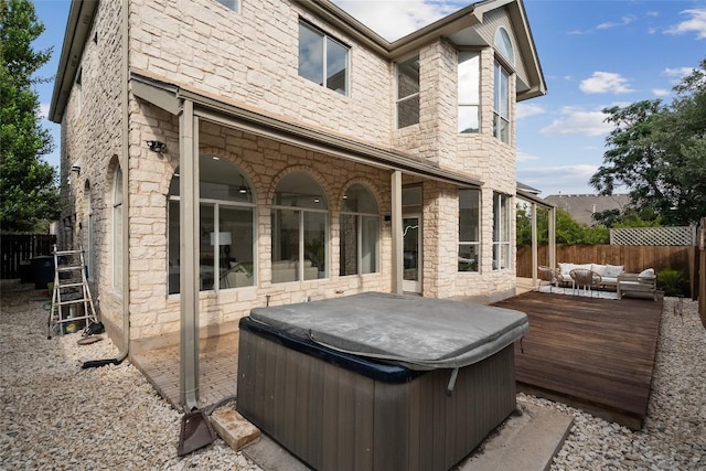 14904 Cordero Dr, Austin, TX 78717 - back of property with a hot tub, an outdoor hangout area, a fenced backyard, and stone siding