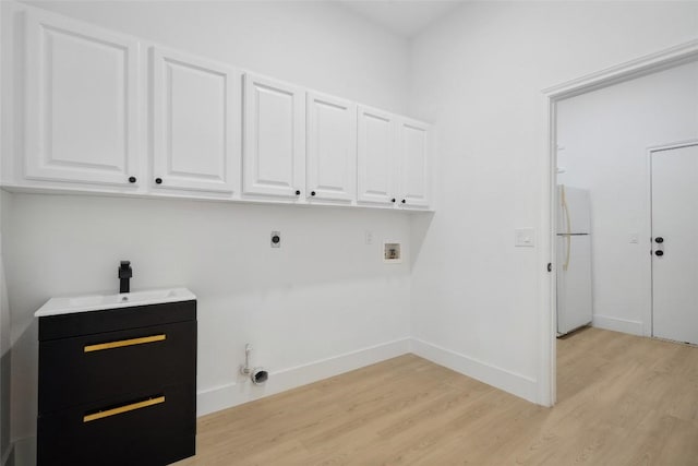 14904 Cordero Dr, Austin, TX 78717 - laundry area with cabinet space, washer hookup, hookup for an electric dryer, light wood-type flooring, and baseboards
