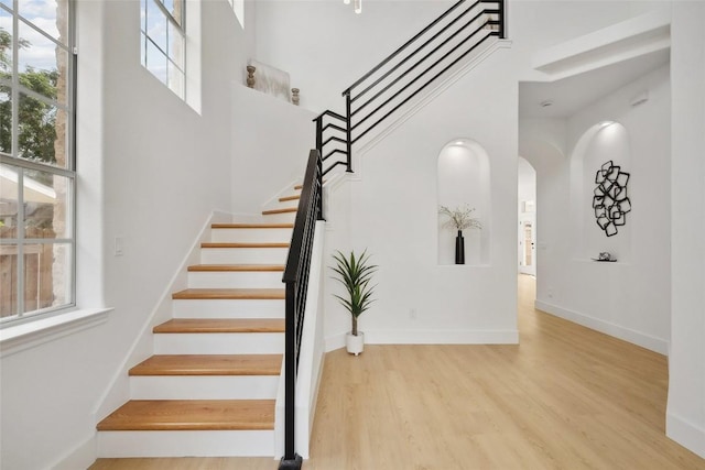14904 Cordero Dr, Austin, TX 78717 - stairway with a high ceiling, plenty of natural light, wood finished floors, arched walkways, and baseboards