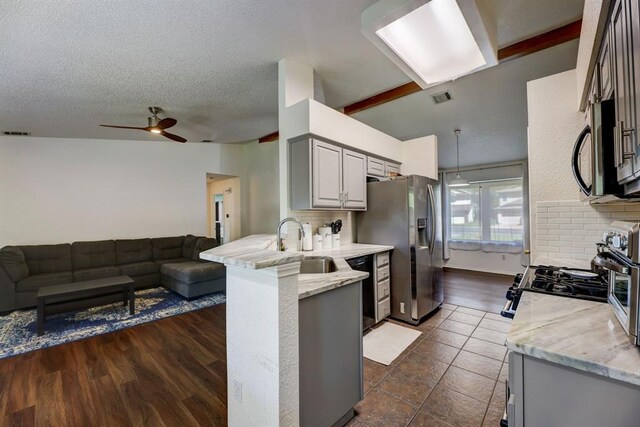 1600 Hatch Rd, Cedar Park, TX 78613 - kitchen featuring appliances with stainless steel finishes, open floor plan, a peninsula, a ceiling fan, and a textured ceiling