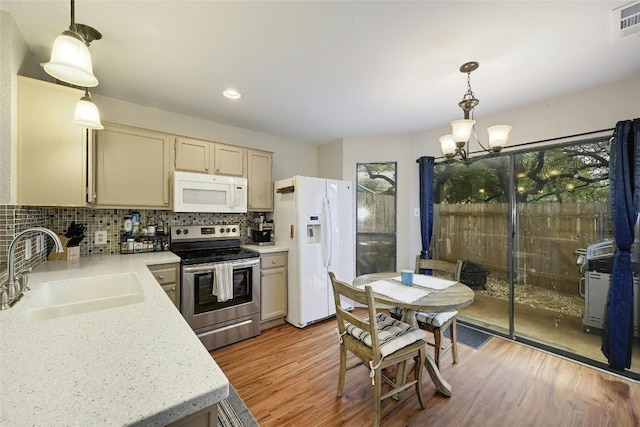 1411 Gracy Farms Ln Unit 69, Austin, TX 78758 - kitchen with white appliances, a sink, a chandelier, light wood-style flooring, and decorative backsplash