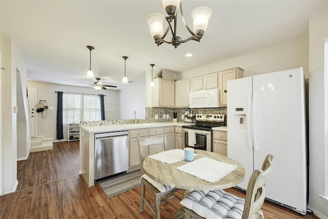 1411 Gracy Farms Ln Unit 69, Austin, TX 78758 - kitchen with stainless steel appliances, a peninsula, backsplash, ceiling fan, and a chandelier