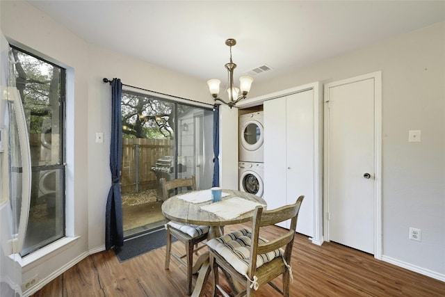 1411 Gracy Farms Ln Unit 69, Austin, TX 78758 - dining space featuring stacked washer and clothes dryer, a chandelier, wood finished floors, and healthy amount of natural light
