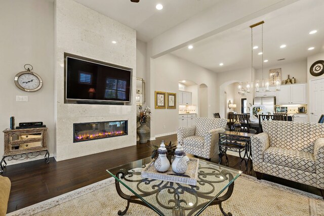 116 Belford St, Georgetown, TX 78628 - living area featuring arched walkways, wood finished floors, a large fireplace, recessed lighting, and baseboards