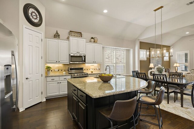 116 Belford St, Georgetown, TX 78628 - kitchen featuring stainless steel appliances, a sink, white cabinetry, dark wood-type flooring, and vaulted ceiling