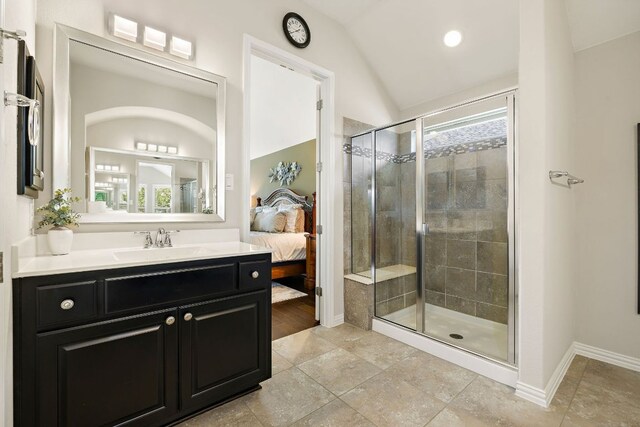 116 Belford St, Georgetown, TX 78628 - bathroom with vaulted ceiling, a stall shower, vanity, connected bathroom, and baseboards