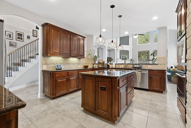 370 Ledge Stone Dr, Austin, TX 78737 - kitchen featuring stainless steel appliances, tasteful backsplash, a peninsula, decorative light fixtures, and a sink