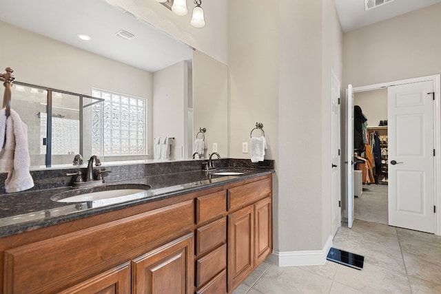 370 Ledge Stone Dr, Austin, TX 78737 - bathroom with double vanity, a shower stall, tile patterned floors, a spacious closet, and baseboards