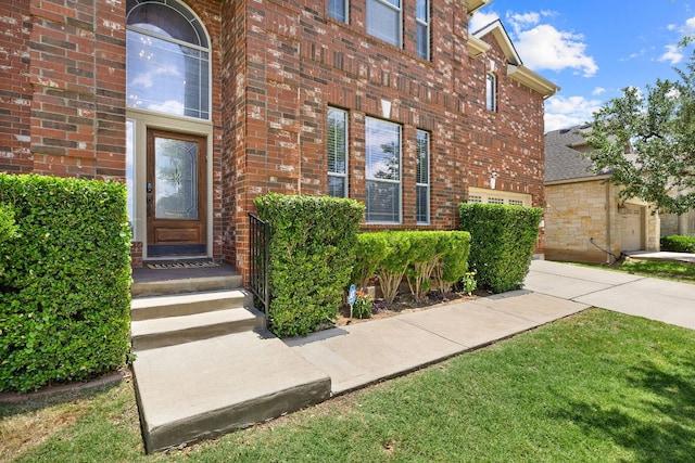 370 Ledge Stone Dr, Austin, TX 78737 - view of exterior entry with brick siding, a lawn, and a garage