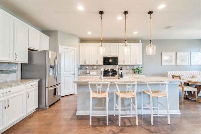 610 Ridge Park Dr, New Braunfels, TX 78130 - kitchen featuring stainless steel appliances, decorative backsplash, white cabinets, recessed lighting, and a kitchen island with sink