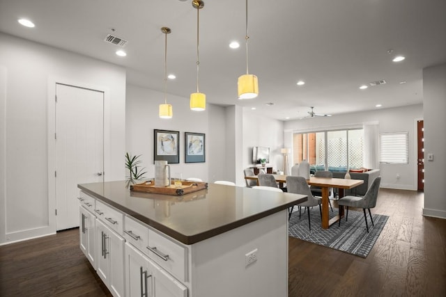 2116 Philomena St, Austin, TX 78723 - kitchen featuring dark countertops, recessed lighting, dark wood-style flooring, a center island, and white cabinetry