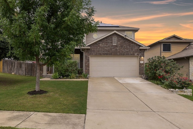 326 Comal Run, Hutto, TX 78634 - view of front facade with roof mounted solar panels, brick siding, driveway, and a garage