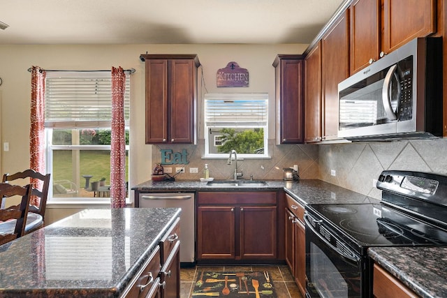 326 Comal Run, Hutto, TX 78634 - kitchen featuring appliances with stainless steel finishes, dark stone counters, tasteful backsplash, and a center island