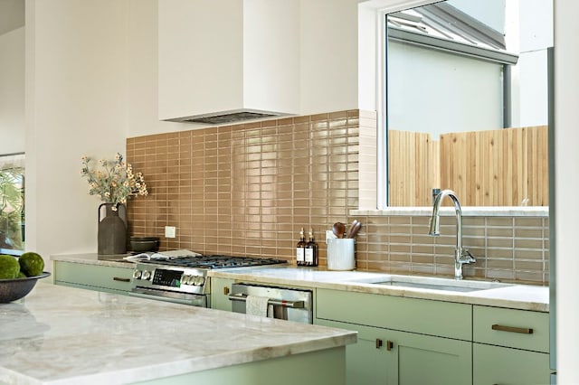 2405 E 22nd St, Austin, TX 78722 - kitchen with green cabinetry, premium range hood, appliances with stainless steel finishes, decorative backsplash, and a sink