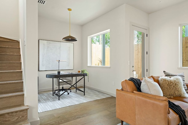 2405 E 22nd St, Austin, TX 78722 - living room with wood finished floors, plenty of natural light, stairway, and baseboards