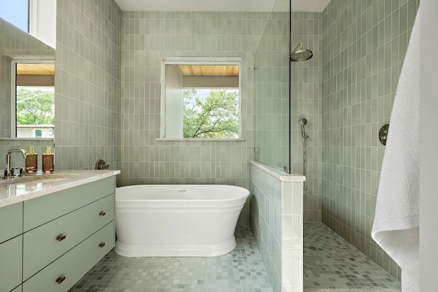 2405 E 22nd St, Austin, TX 78722 - bathroom featuring tile walls, a freestanding bath, walk in shower, vanity, and tile patterned flooring