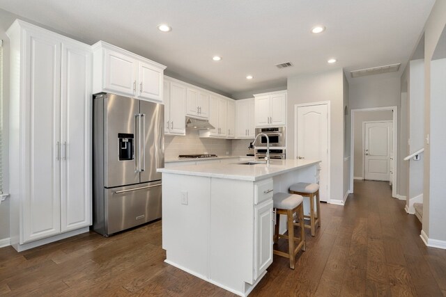 7221 Seneca Falls Loop, Austin, TX 78739 - kitchen with high quality fridge, decorative backsplash, white cabinetry, a kitchen breakfast bar, and recessed lighting