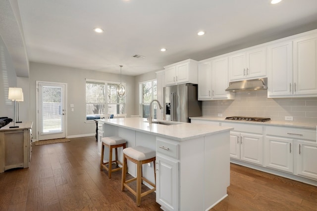 7221 Seneca Falls Loop, Austin, TX 78739 - kitchen featuring under cabinet range hood, a sink, appliances with stainless steel finishes, recessed lighting, and a kitchen island with sink