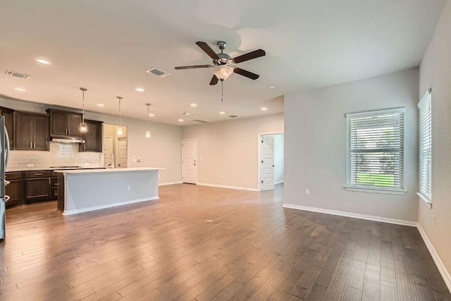 8817 Slater Dr, Austin, TX 78747 - unfurnished living room with ceiling fan, recessed lighting, baseboards, wood finished floors, and a sink