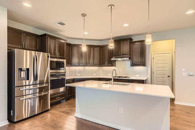 8817 Slater Dr, Austin, TX 78747 - kitchen featuring appliances with stainless steel finishes, a sink, dark brown cabinetry, light countertops, and recessed lighting