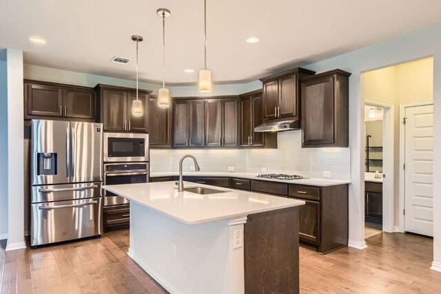 8817 Slater Dr, Austin, TX 78747 - kitchen featuring stainless steel appliances, a sink, dark brown cabinetry, light wood-style floors, and recessed lighting