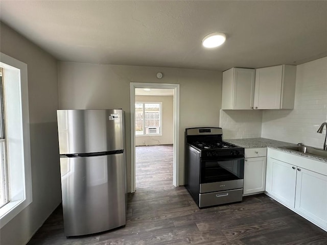 808 E 46th St Unit C, Austin, TX 78751 - kitchen with stainless steel appliances, a sink, dark wood-style floors, and white cabinetry