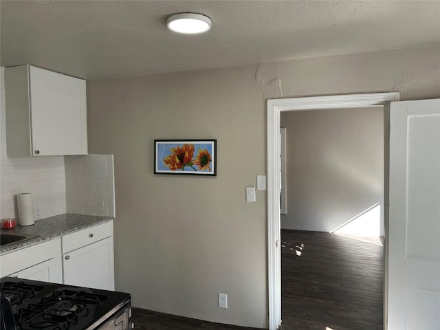 808 E 46th St Unit C, Austin, TX 78751 - kitchen with tasteful backsplash, dark wood-style floors, white cabinetry, and range with gas stovetop