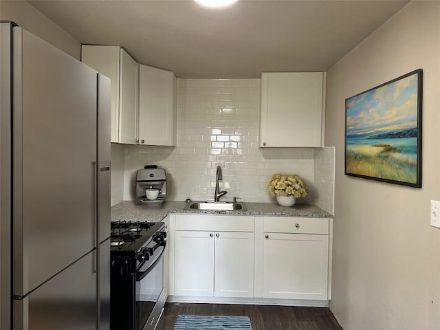 808 E 46th St Unit C, Austin, TX 78751 - kitchen featuring freestanding refrigerator, a sink, black gas stove, and white cabinetry