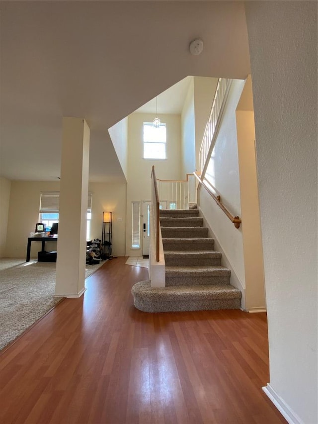14501 Dreamtime Ln, Pflugerville, TX 78660 - stairs featuring wood finished floors, baseboards, and a towering ceiling