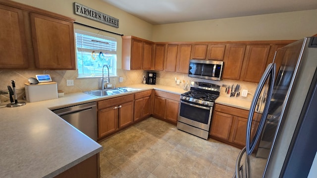 14501 Dreamtime Ln, Pflugerville, TX 78660 - kitchen featuring appliances with stainless steel finishes, a sink, brown cabinetry, backsplash, and light countertops