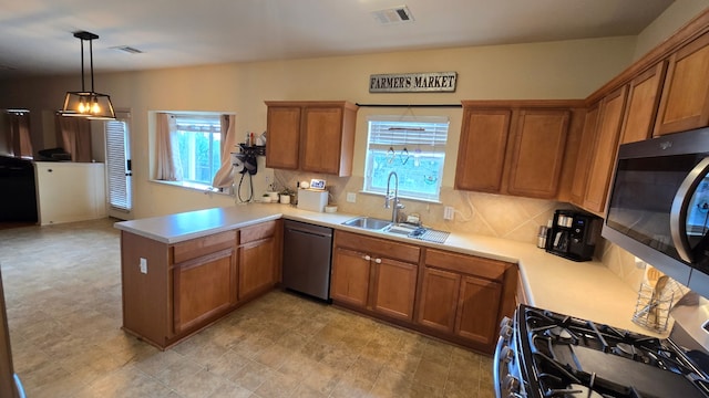 14501 Dreamtime Ln, Pflugerville, TX 78660 - kitchen featuring stainless steel appliances, a sink, plenty of natural light, and brown cabinets
