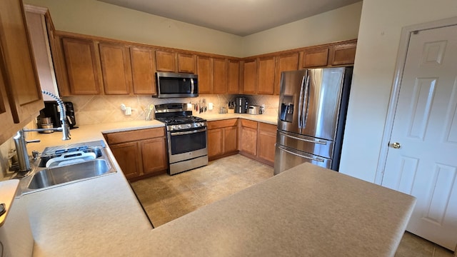 14501 Dreamtime Ln, Pflugerville, TX 78660 - kitchen featuring stainless steel appliances, backsplash, a sink, brown cabinetry, and light countertops