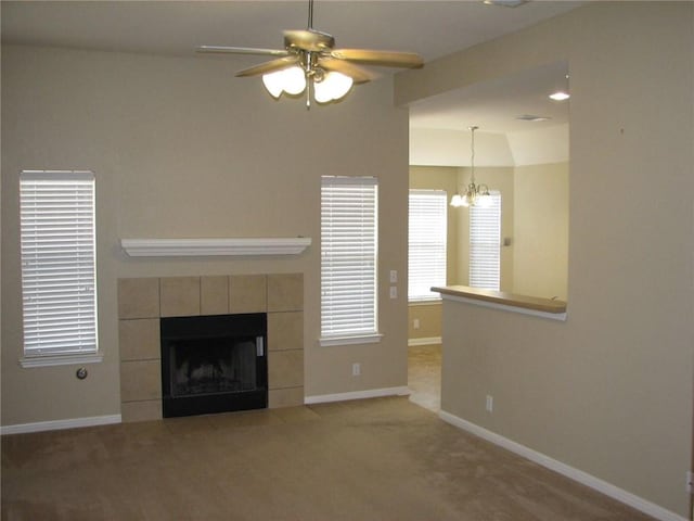 123 Bayliss St, Hutto, TX 78634 - unfurnished living room with a ceiling fan, a chandelier, baseboards, a fireplace, and carpet floors