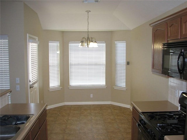 123 Bayliss St, Hutto, TX 78634 - kitchen featuring gas range, black microwave, a chandelier, lofted ceiling, and decorative light fixtures
