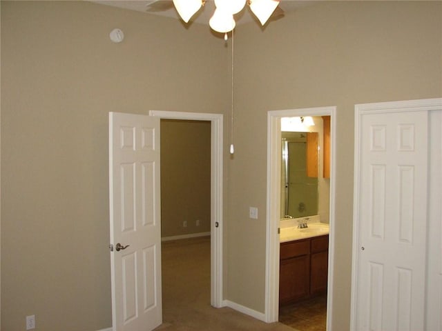 123 Bayliss St, Hutto, TX 78634 - unfurnished bedroom featuring ensuite bathroom, baseboards, a sink, and a ceiling fan