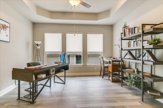 3221 Venezia Vw, Leander, TX 78641 - home office featuring a tray ceiling, ceiling fan, and wood finished floors