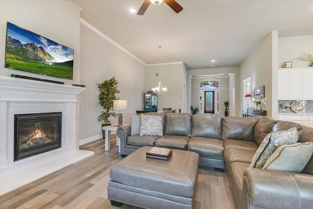 3221 Venezia Vw, Leander, TX 78641 - living room featuring ceiling fan, light wood finished floors, a chandelier, a glass covered fireplace, and recessed lighting