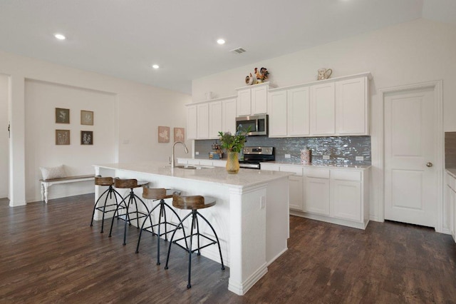 1437 Morning View Rd, Georgetown, TX 78628 - kitchen with stainless steel appliances, a sink, backsplash, a breakfast bar, and dark wood-type flooring